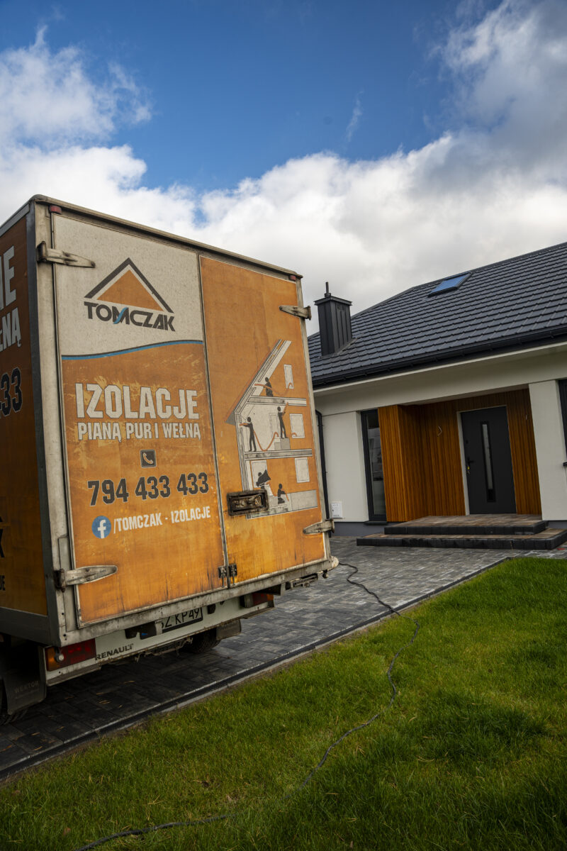 Samochód firmy Tomczak Izolacje przed domem ocieplanym pianą PUR w Olsztynie